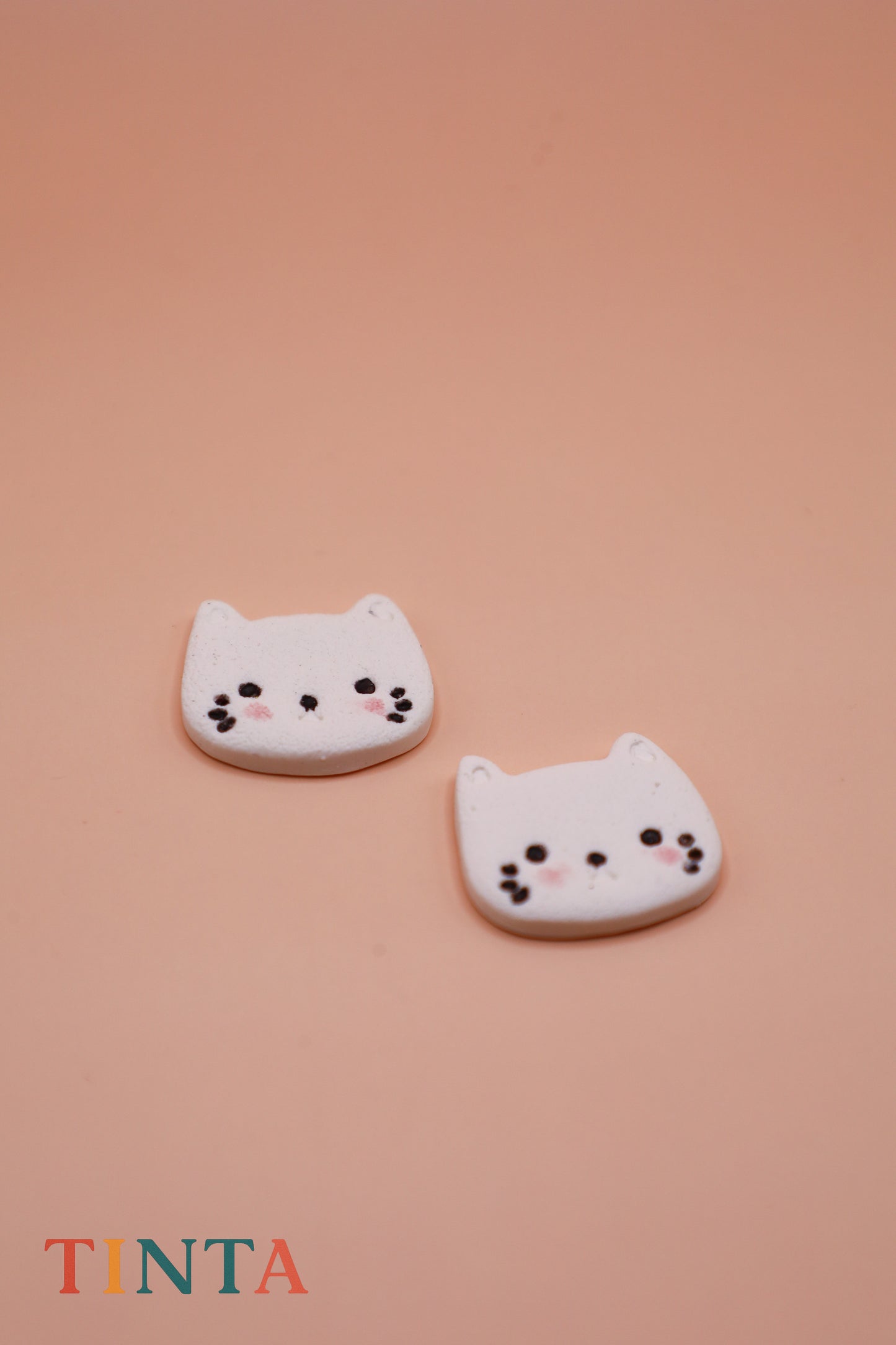 Two cat-shaped cookies on a pink background with 'TINTA' branding.