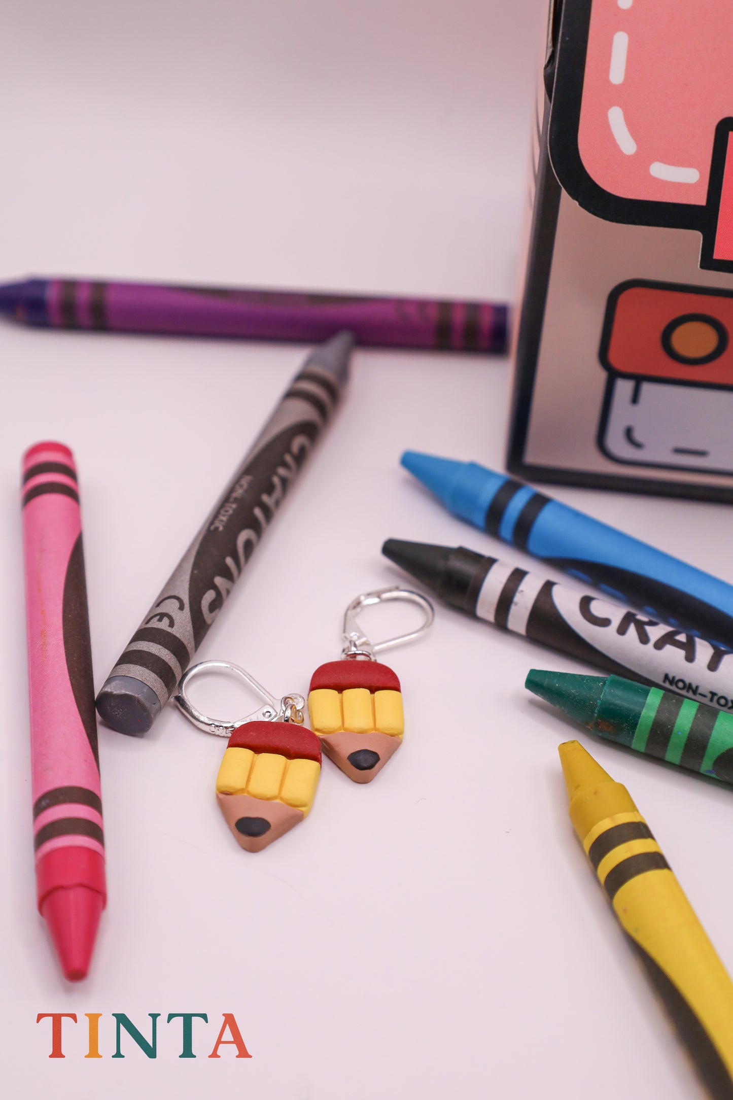Colorful crayon-shaped keychains with a box labeled 'Crayola' on a white background.
