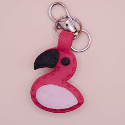 Flamingo-shaped keychain on a pink background with 'TINTA' branding.