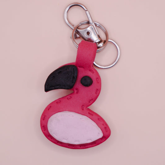 Flamingo-shaped keychain on a pink background with 'TINTA' branding.