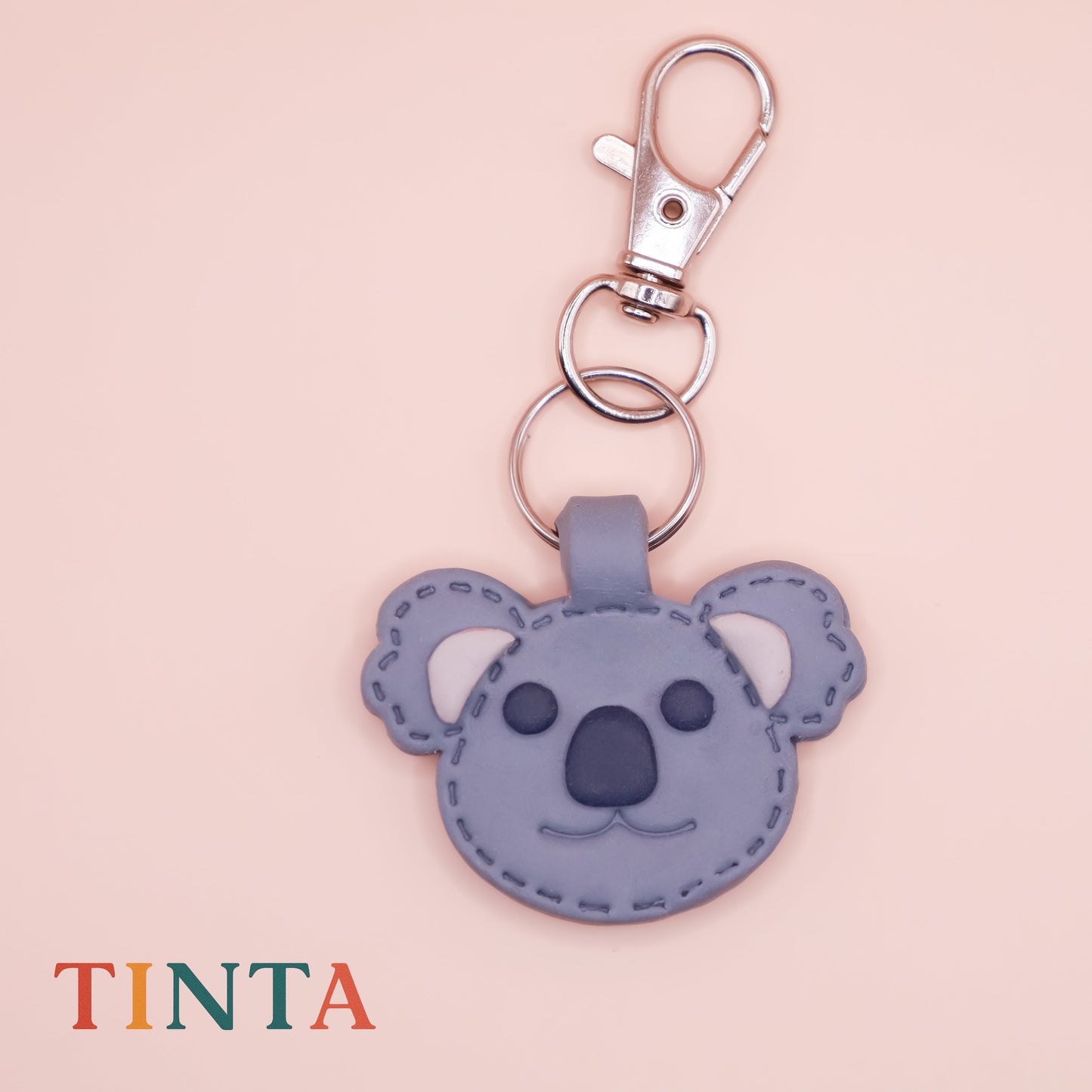 Keychain with koala design on a pink background, featuring the brand 'Tinta'.