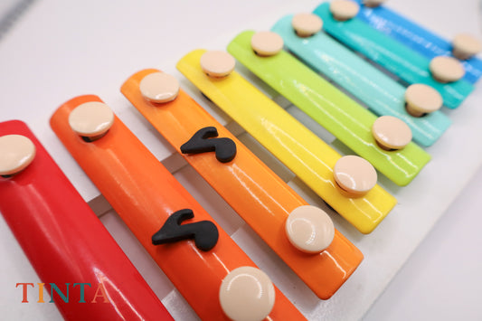 Colorful xylophone with wooden notes on a white background, featuring the brand 'Tinta'.