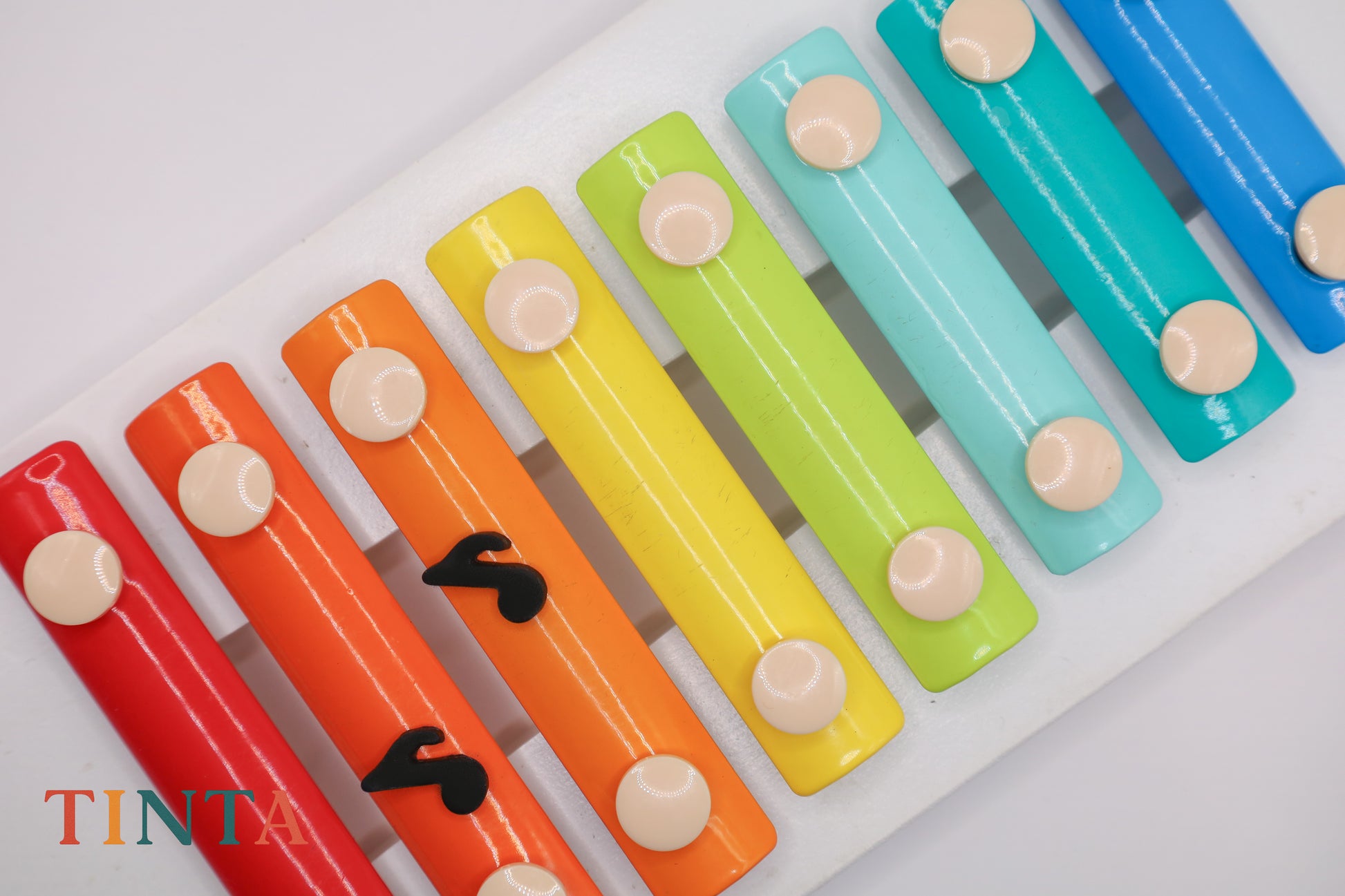 Colorful xylophone with red, orange, yellow, green, blue, and purple keys on a white background.