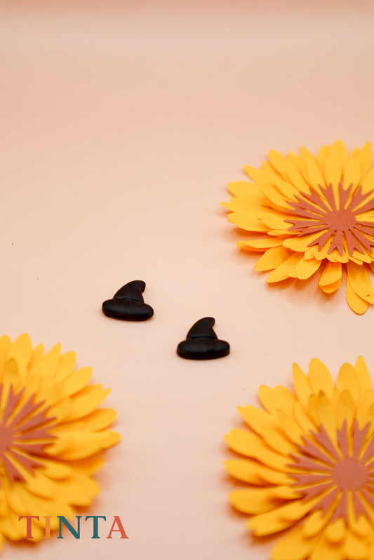 Yellow flower-shaped cookies with black decorations on a beige background, featuring the brand 'Tinta'.