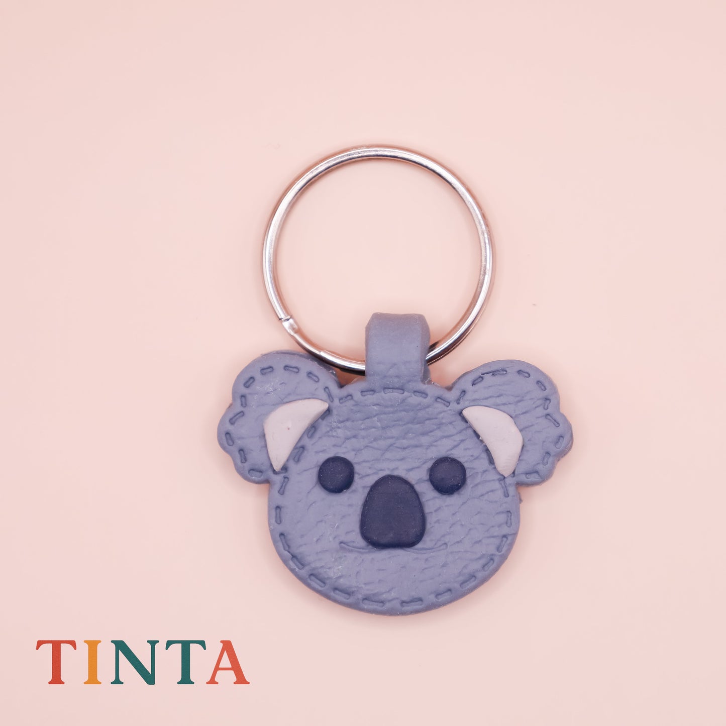 Keychain shaped like a koala on a pink background with 'TINTA' branding.